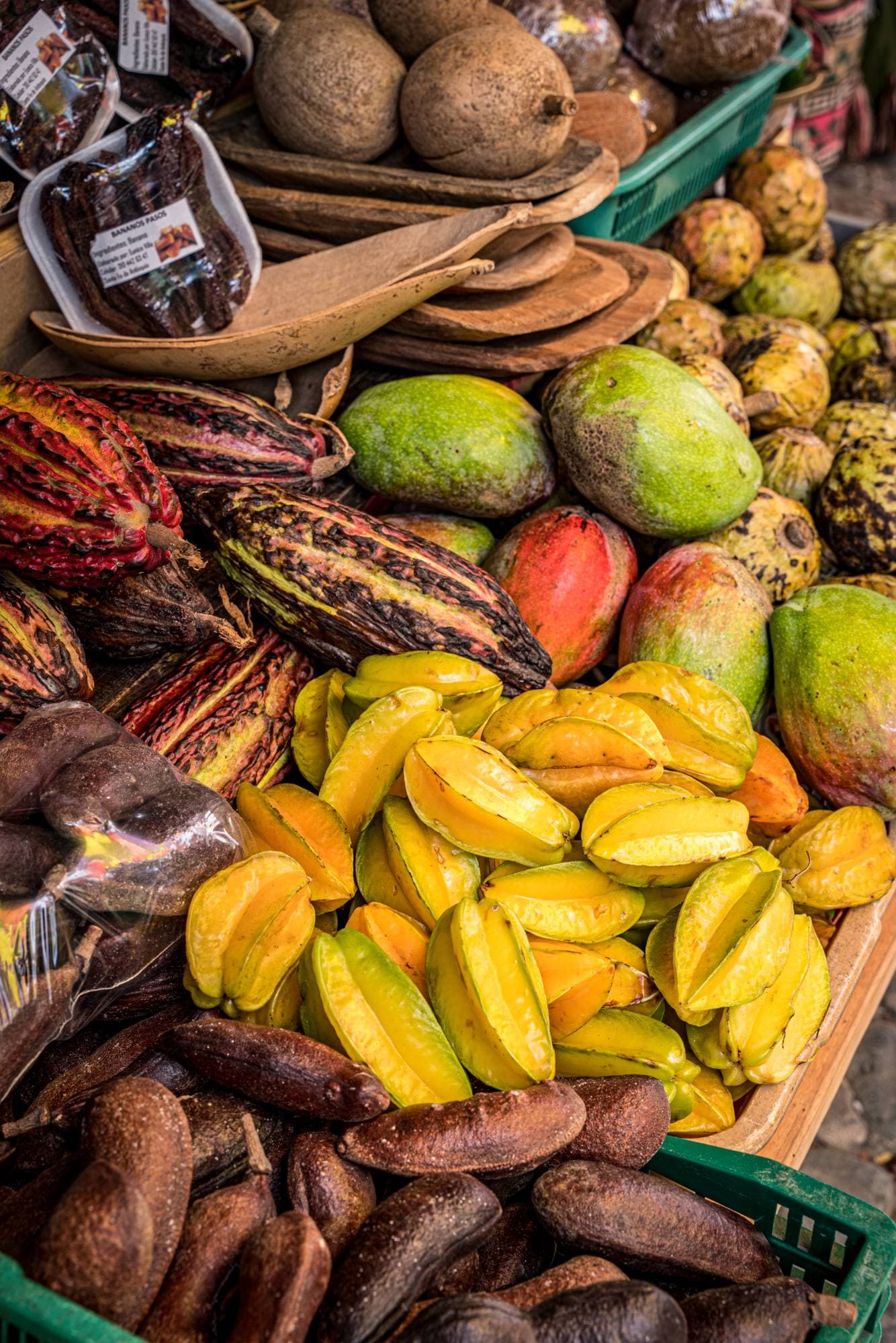 Frutas exóticas colombianas — carambolo, cacao y mangos — en un mercado local